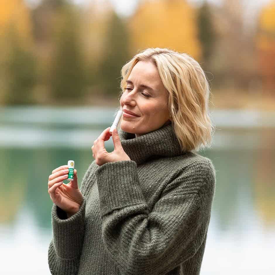 Woman holding Makasa Etch Blueprint outdoors in autumn.