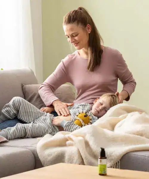 Woman applying Makasa Etch to child's arm on sofa.