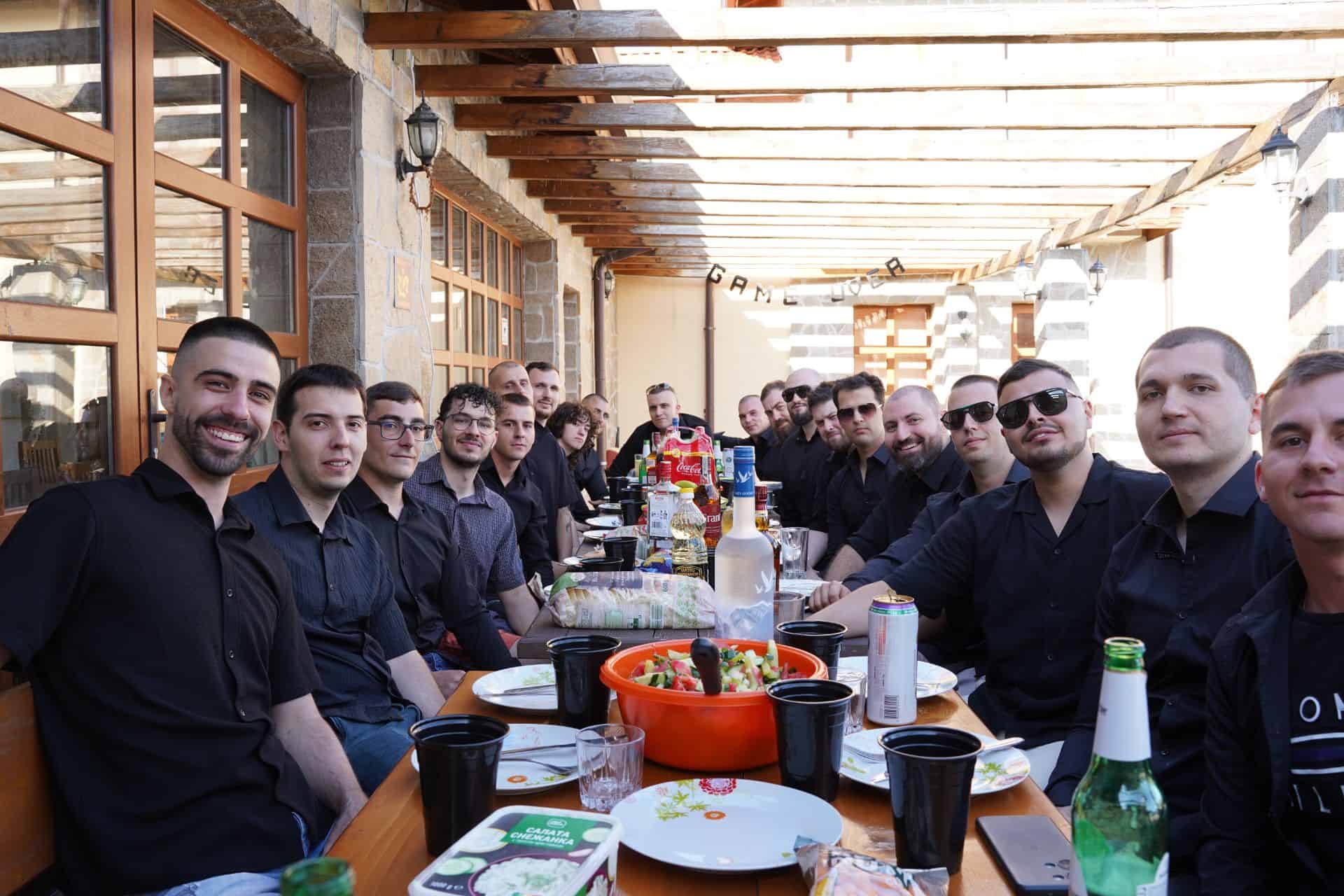 Group of people dining outdoors with Makasa Etch Blueprint in focus.