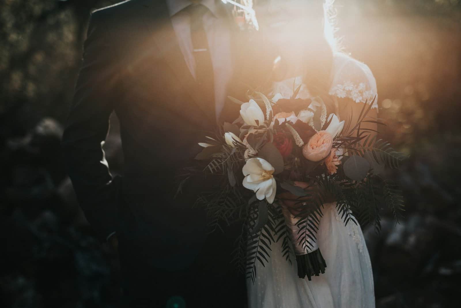 Etch Blueprint wedding couple with floral bouquet at sunset.