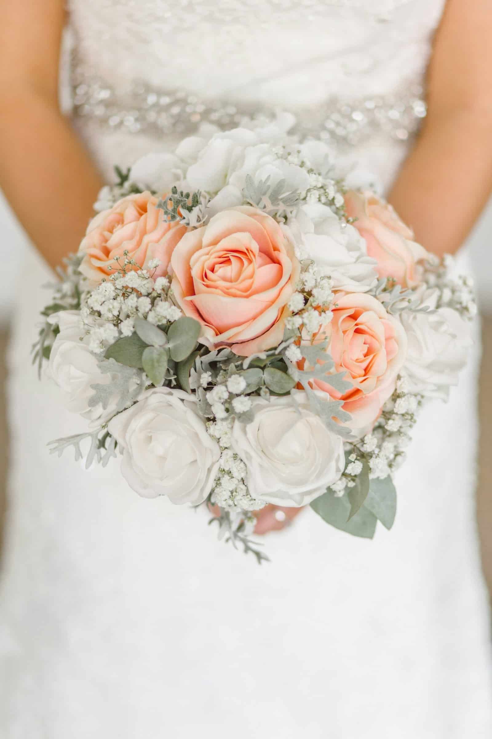 Elegant wedding bouquet with peach roses and white flowers.